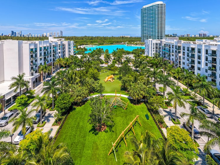 A view of a resort with a pool and palm trees.